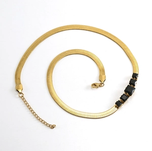 Detail of 18k gold plated snake chain necklace with five square black zircon gemstones