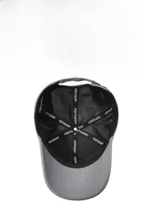 Detail view of the breathable black mesh interior and seam tape of the grey baseball cap
