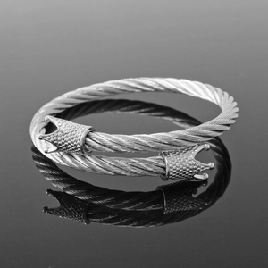 Detailed macro view of a silver steel cable bracelet with dual crown clasps on reflections