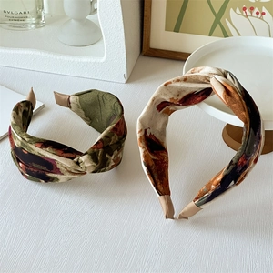 Detailed view of wide printed knot headbands with abstract patterns on white surface