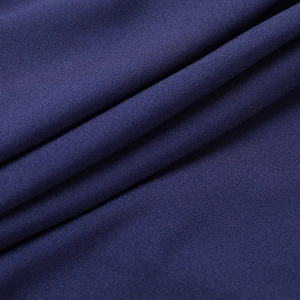 Detailed macro view of dark blue knitted fabric with tight texture and elegant drape