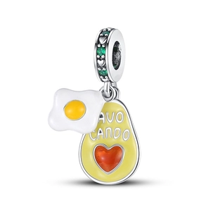 Macro shot of silver avocado charm with heart gemstone and enamel fried egg detail