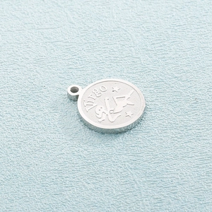 Macro shot of silver stainless steel Virgo zodiac pendant with female figure and stars
