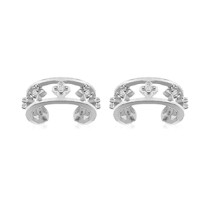 Detailed macro view of silver hollow floral ear cuffs with zircon inlays and polished finish