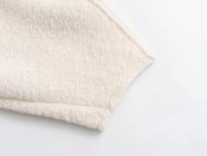 Close-up of the soft cream-white sherpa fleece fabric texture on the casual sweater