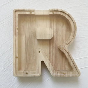Detail of R-shaped oak wood money box with transparent acrylic cover and gold screws