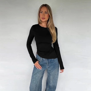 Detail of a black long-sleeve slim-fit top with an asymmetric hem on a fashion model