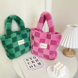 Macro detail of plush checkerboard bucket bags showing soft fuzzy texture in pink and green