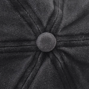 Détail macro du bouton supérieur et de la texture en sergé d'une casquette de baseball lavée