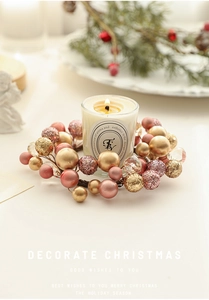 Detail of pink and gold beaded Christmas wreath with a glass scented candle centerpiece
