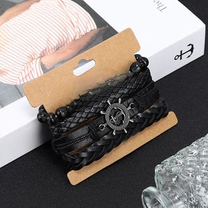 Détail d'un ensemble de bracelets en cuir pour hommes avec breloque ancre sur carte