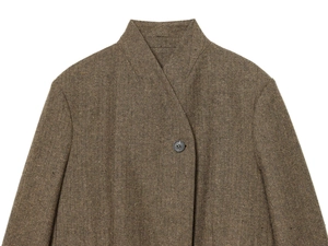 Close-up of brown herringbone blazer featuring collar detail and premium buttons