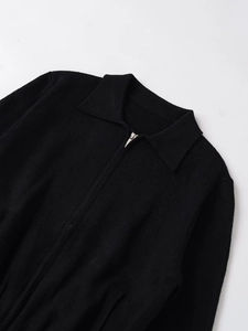 Detail der schwarzen Strickjacke mit Polokragen und Reißverschluss aus feinem Strick