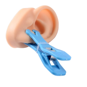 Blue acrylic piercing clamp used on silicone ear model for precision ear piercing procedure