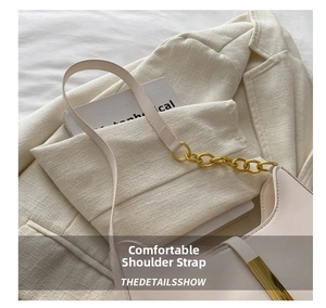 Close-up of beige leather shoulder bag with textured surface and gold chain detail