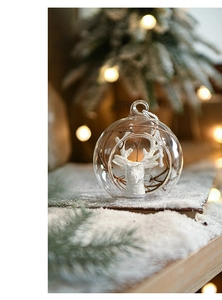 Detail of a Christmas glass ball with a white deer head statue and festive snow decor