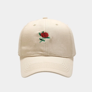 Dettaglio del ricamo rosa rossa su un cappellino da baseball in cotone beige morbido