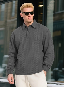 Detailed macro view of dark grey men's knitted polo shirt with diamond jacquard texture