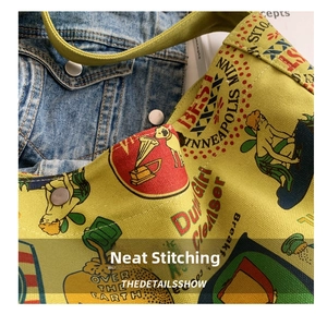 Detailed close-up of yellow canvas bag showing vintage print and metal rivet reinforcement