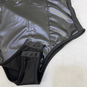 Vue détaillée du fermoir à boutons-pression sur un body noir en cuir PU