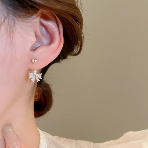 Close-up of elegant silver bow earrings with sparkling cubic zirconia on female model