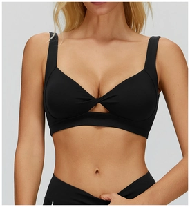 Dettaglio del reggiseno sportivo nero con nodo a torsione e apertura a triangolo frontale