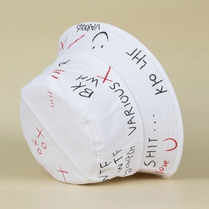 Close-up of white canvas bucket hat featuring black and red street graffiti prints