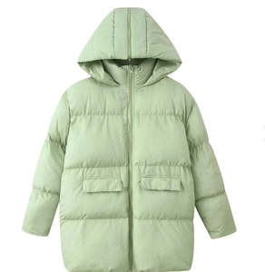 Detail view of light green hooded puffer jacket featuring zip closure and flap pockets