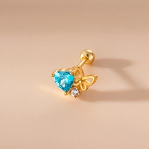 Detail of gold ear stud featuring blue heart zircon, butterfly charm, and screw back closure