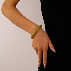 Detail of green translucent acrylic bangle with vintage marbled effect on wrist
