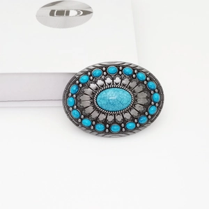 Detail of oval vintage silver belt buckle with turquoise stones in western style