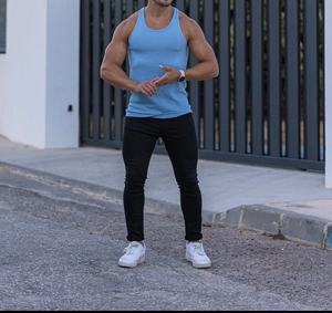 Detail of light blue ribbed knit sleeveless sports vest on male model outdoors