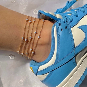 Bohemian gold layered anklets with light blue flower charms shown on ankle