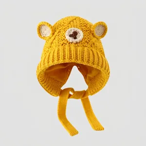 Detailed knit texture of bright yellow bear ear beanie with secure chin straps
