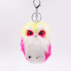 Close-up of tricolor plush owl keychain with soft yellow pink and white faux fur detail