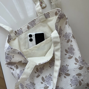 Internal wall pocket of floral cotton tote bag showing storage for a mobile phone