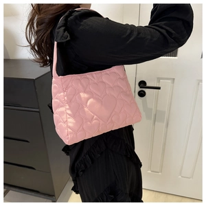 Détail du sac à bandoulière rose matelassé à cœurs en tissu nylon de qualité