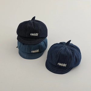 Close-up of denim baby newsboy caps with Hello embroidery and cute pointed top details