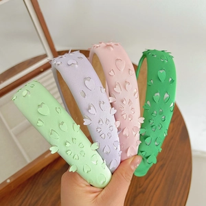 Detail of pink and pastel hollow-out floral headbands held by hand for a close-up view