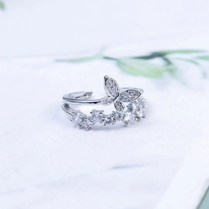 Silver double butterfly adjustable ring with sparkling cubic zirconia on a light base