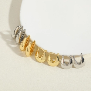 Macro display of thick chunky U-shaped hoop earrings in polished gold and silver finishes