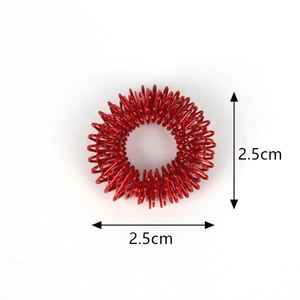 Detail view of a red metal acupressure massage ring with a 2.5cm diameter dimension