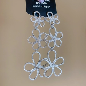 Close-up of silver-tone hollow flower drop earrings featuring sparkling rhinestones