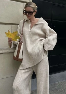 Detail shot of beige knit set with half-zip collar sweater and wide-leg trousers