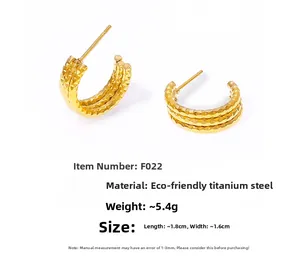 Detail of 18k gold plated titanium steel C-hoop earrings with triple layered texture