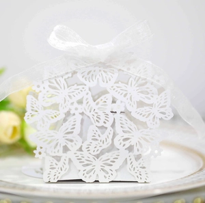 Detail showing white laser-cut butterfly candy box with a satin ribbon bow tie