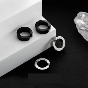 Minimalist titanium steel hoop earrings in black and silver on a modern white display