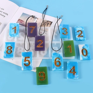 Detail of colorful resin rectangle number pendants in marble texture with gold metal charms