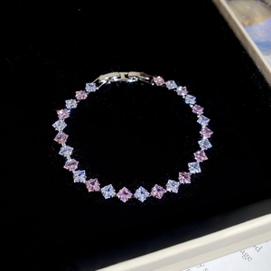 Detail of silver tennis bracelet with pink and white square zircons on black velvet tray