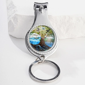 Detail of metal nail clipper keychain with tree of life glass gem art on stone backdrop